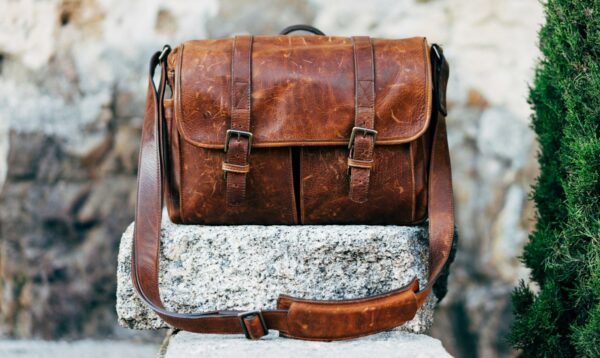 Bags Brown leather satchel bag resting on a concrete surface